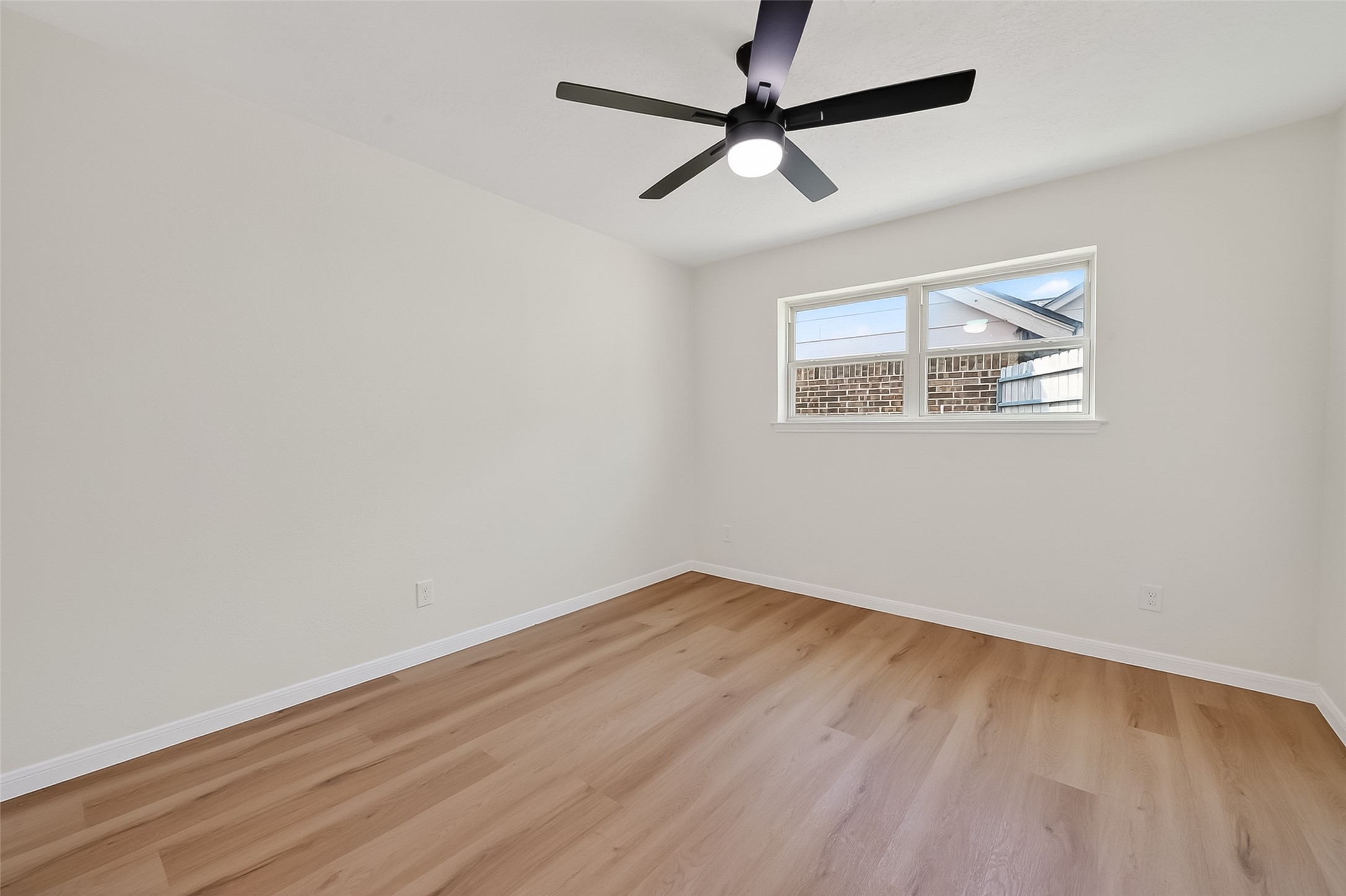 2914 Riata Lane Houston, TX 77043 - Photo 34 of 46 an empty room with wooden floor ceiling fan and windows