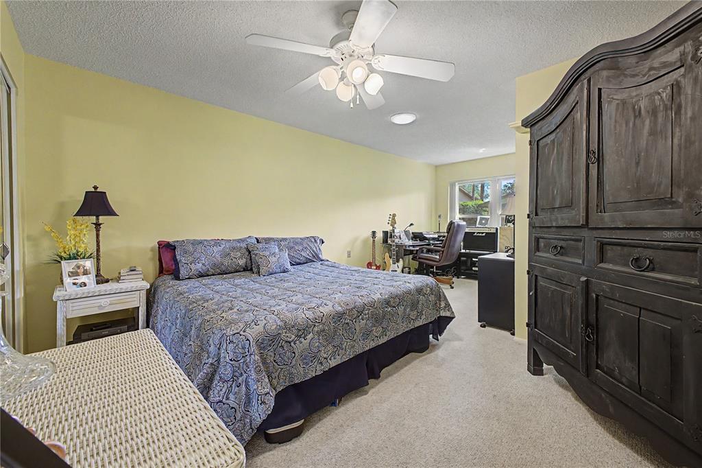 2662 Appleleaf Court Spring Hill, FL 34606 - Photo 24 of 47 a bedroom with a bed dresser and a chandelier