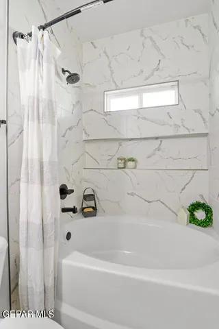 a bathroom with a shower and a bath tub