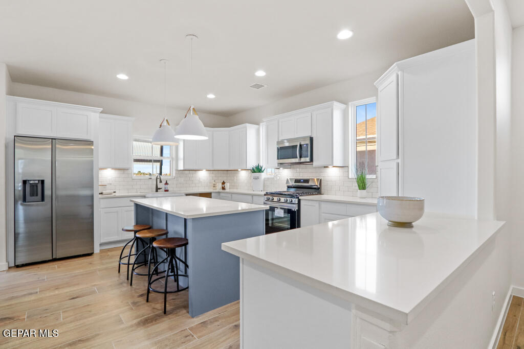 14952 Hill Ridge El Paso, TX 79938 - Photo 8 of 38 a kitchen with stainless steel appliances kitchen island granite countertop a refrigerator a stove a sink a dining table and chairs