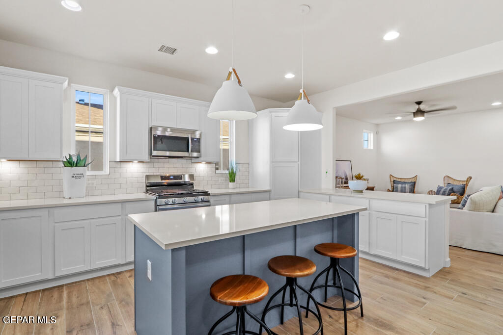 14952 Hill Ridge El Paso, TX 79938 - Photo 10 of 38 a kitchen with stainless steel appliances a dining table chairs stove sink and cabinets