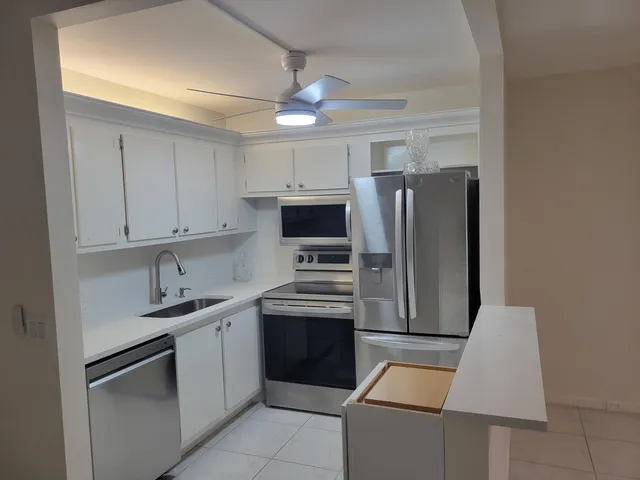 a kitchen with stainless steel appliances granite countertop a refrigerator sink and stove