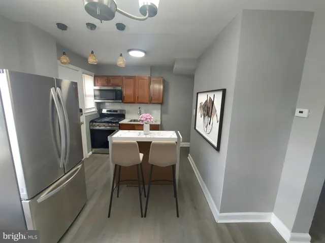 a kitchen with stainless steel appliances a refrigerator a microwave a sink and a refrigerator