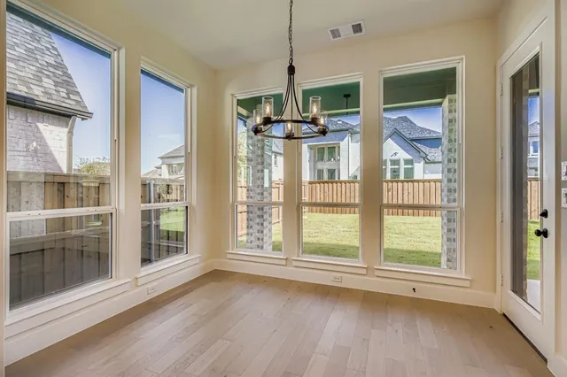 a view of a room with wooden floor and windows