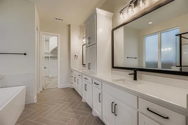 a bathroom with a double vanity sink and mirror with shower