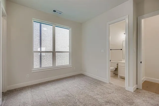an empty room that has a large window and bathroom view