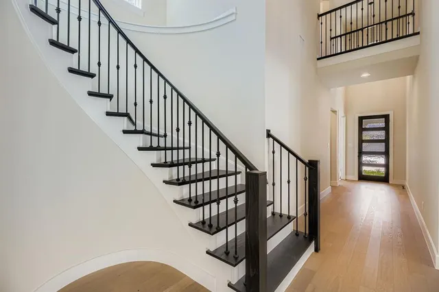 a view of staircase with wooden floor and a chandelier