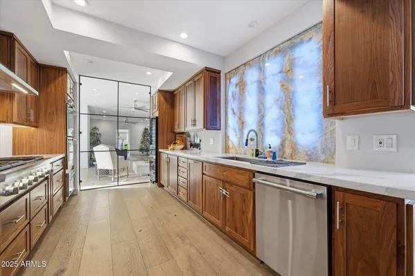 a kitchen with stainless steel appliances granite countertop a refrigerator a sink dishwasher stove and cabinets