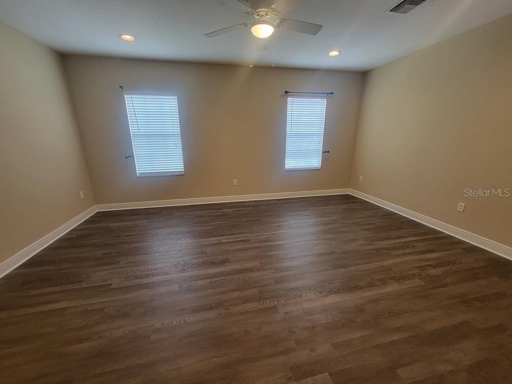 10418 Fenceline Road New Port Richey, FL 34655 - Photo 19 of 36 an empty room with wooden floor and windows