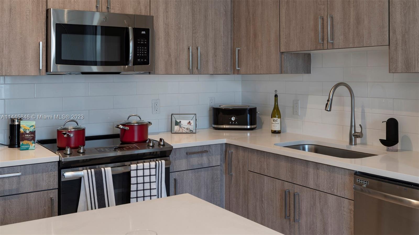 2701 Biscayne Boulevard, Unit 4111 Miami, FL 33137 - Photo 8 of 45 a kitchen with stainless steel appliances granite countertop a sink stove and microwave