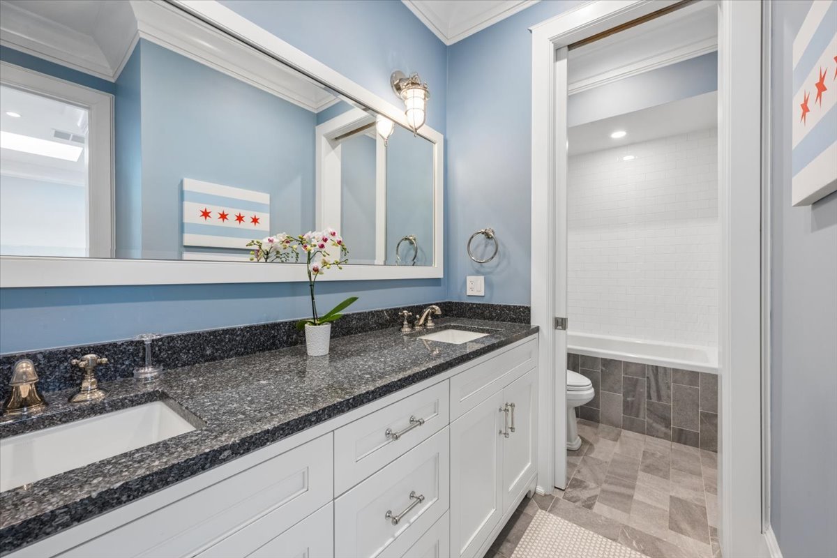 458 West Deming Place Chicago, IL 60614 - Photo 32 of 39 a bathroom with a granite countertop sink and a mirror