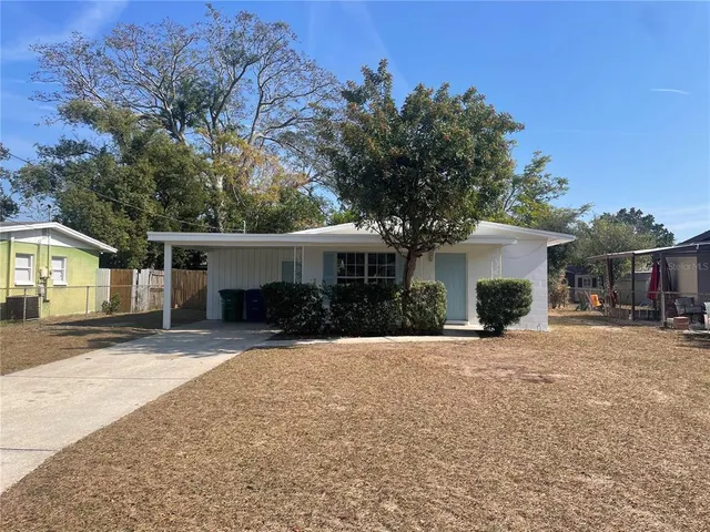 a front view of house with yard and trees in the background