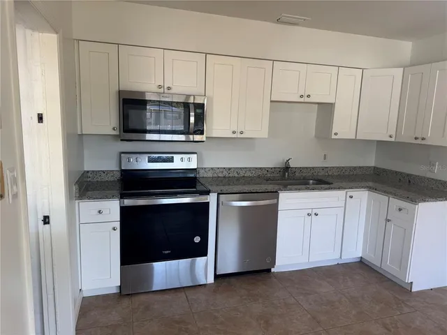 a kitchen with stainless steel appliances granite countertop a stove and a microwave