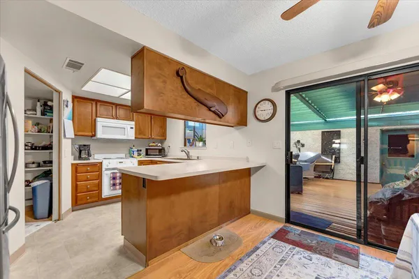 a kitchen with stainless steel appliances granite countertop a stove and a view of living room