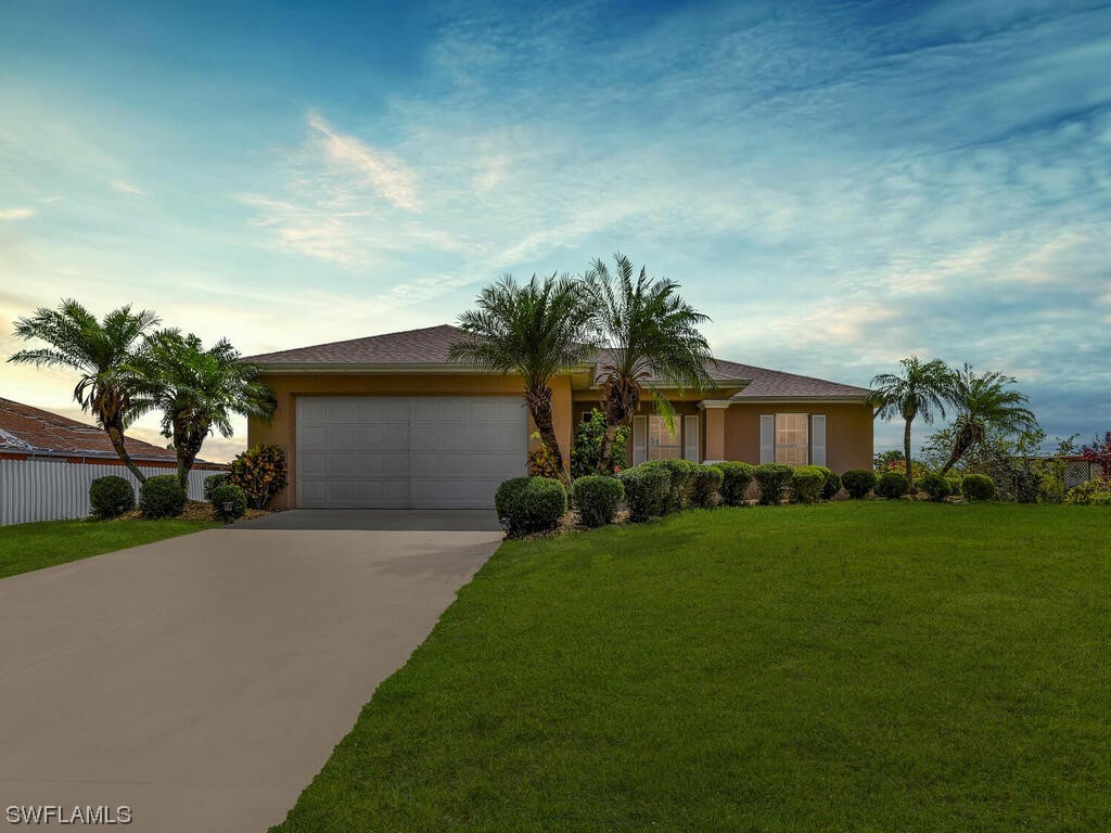 a front view of a house with a yard and trees