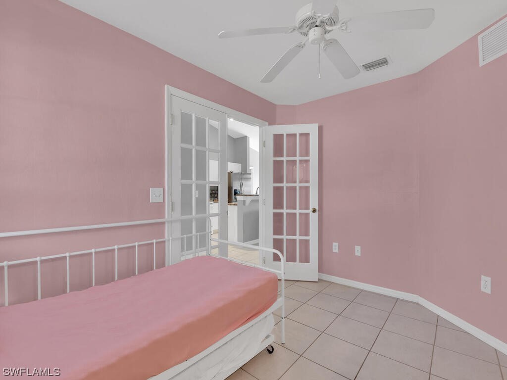 3960 Sunset Road Lehigh Acres, FL 33971 - Photo 12 of 23 a bedroom with a bed and chandelier