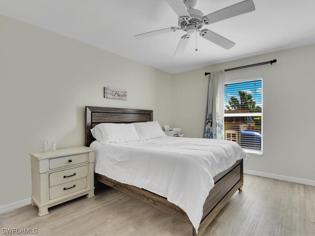 3960 Sunset Road Lehigh Acres, FL 33971 - Photo 13 of 23 a bedroom with a bed and a chandelier