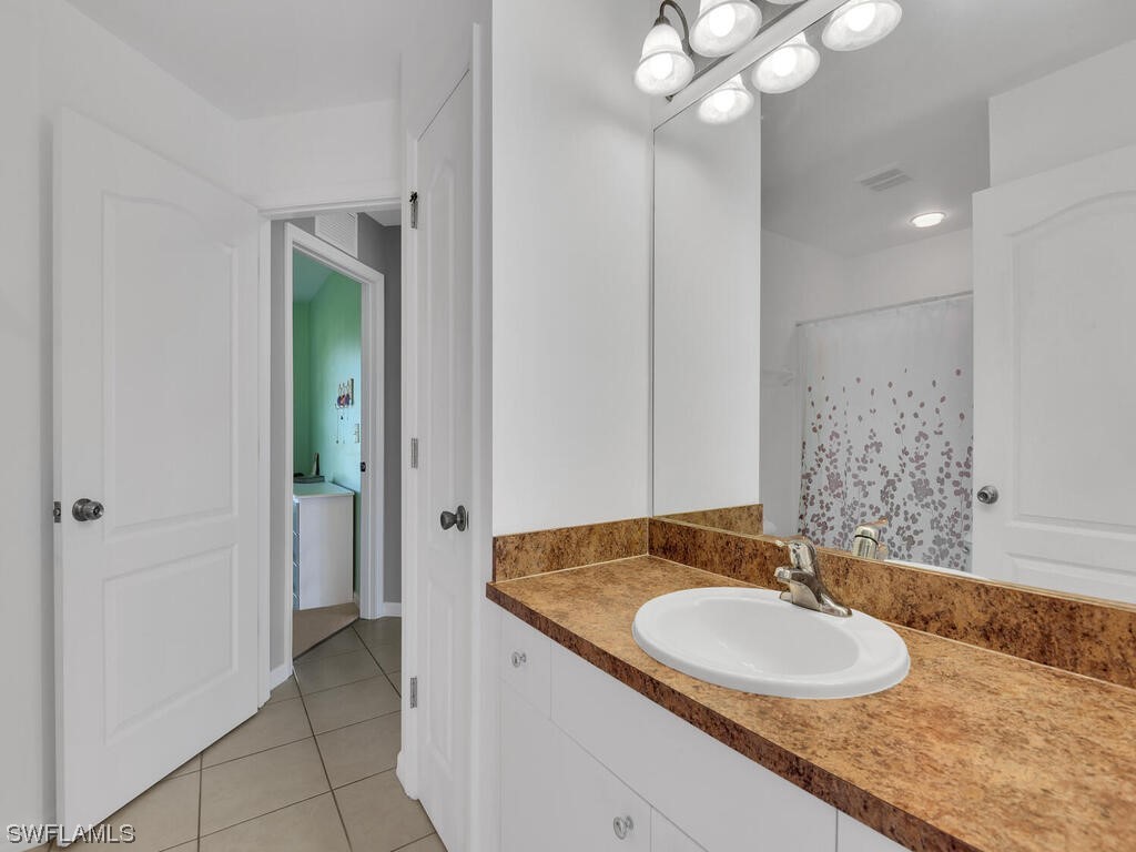 3960 Sunset Road Lehigh Acres, FL 33971 - Photo 17 of 23 a bathroom with a granite countertop sink and a mirror