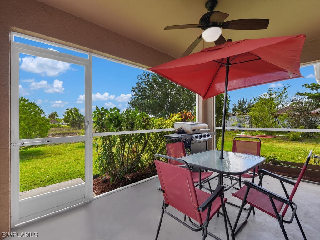 3960 Sunset Road Lehigh Acres, FL 33971 - Photo 21 of 23 a view of a balcony with chairs and table under an umbrella