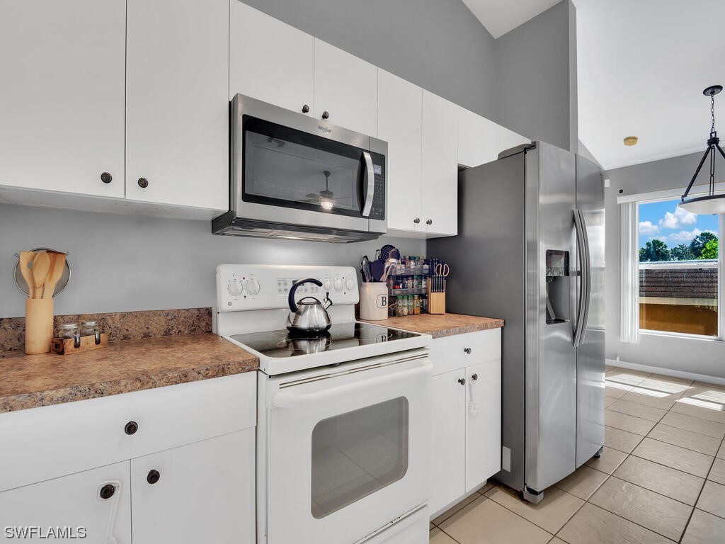 3960 Sunset Road Lehigh Acres, FL 33971 - Photo 4 of 23 a kitchen with granite countertop a sink stove and refrigerator