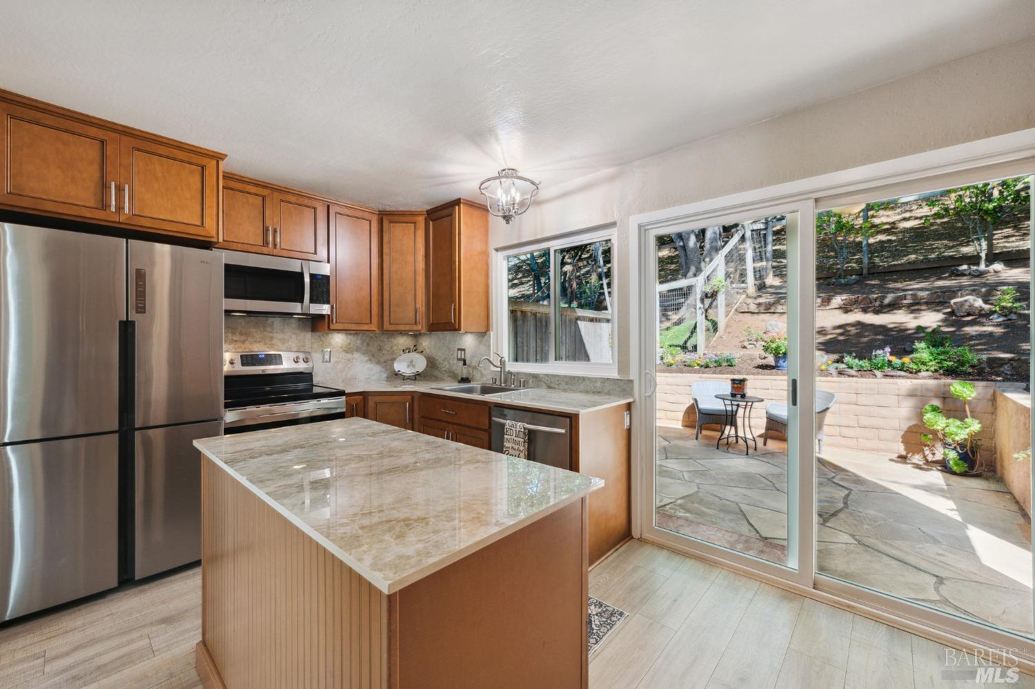 19 Libra Drive Novato, CA 94947 - Photo 1 of 1 a kitchen with stainless steel appliances granite countertop a refrigerator a stove top oven a sink a dining table and chairs with wooden floor