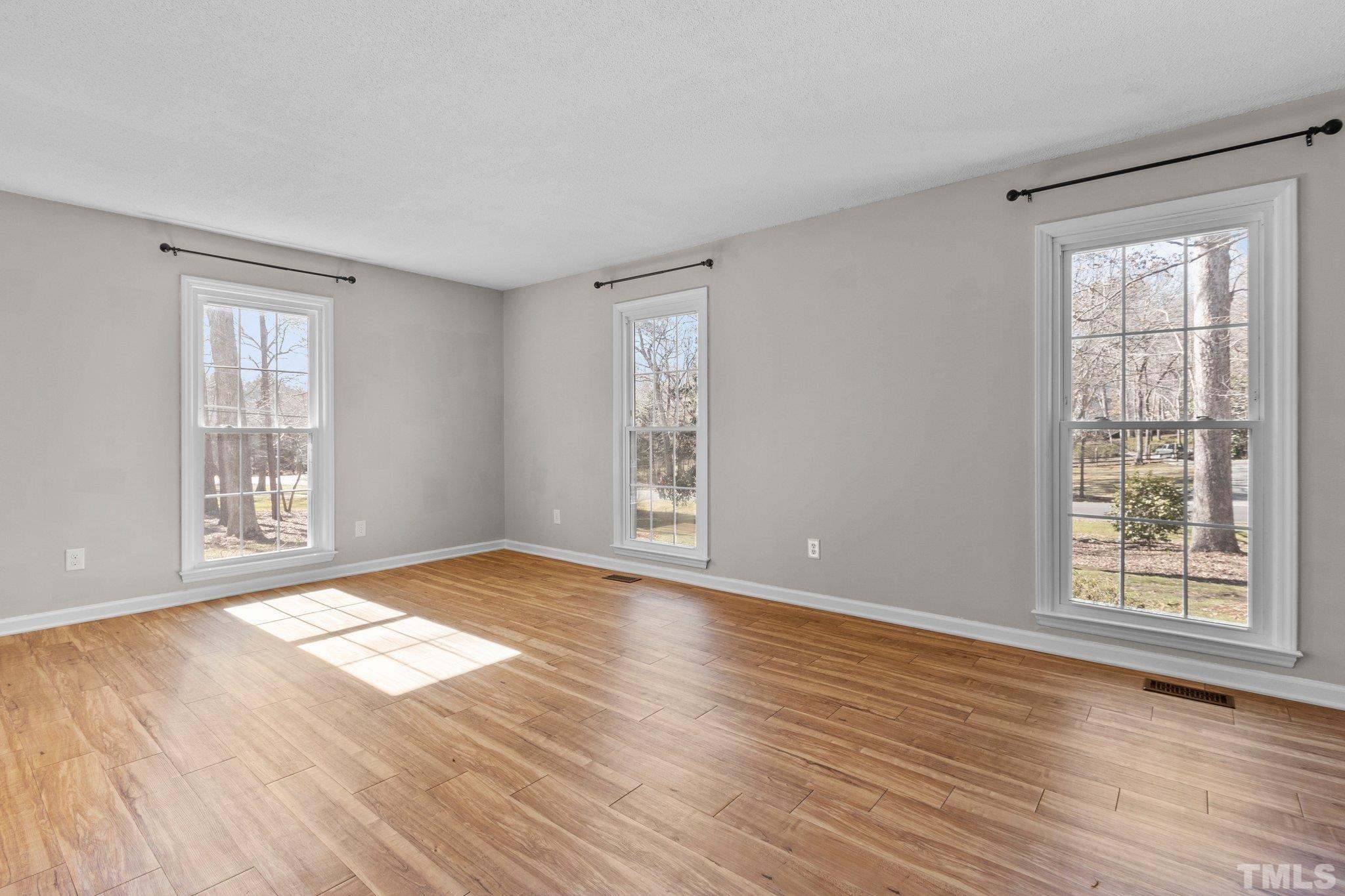 5216 Hallmark Road Durham, NC 27712 - Photo 4 of 24 a view of an empty room with wooden floor and a window