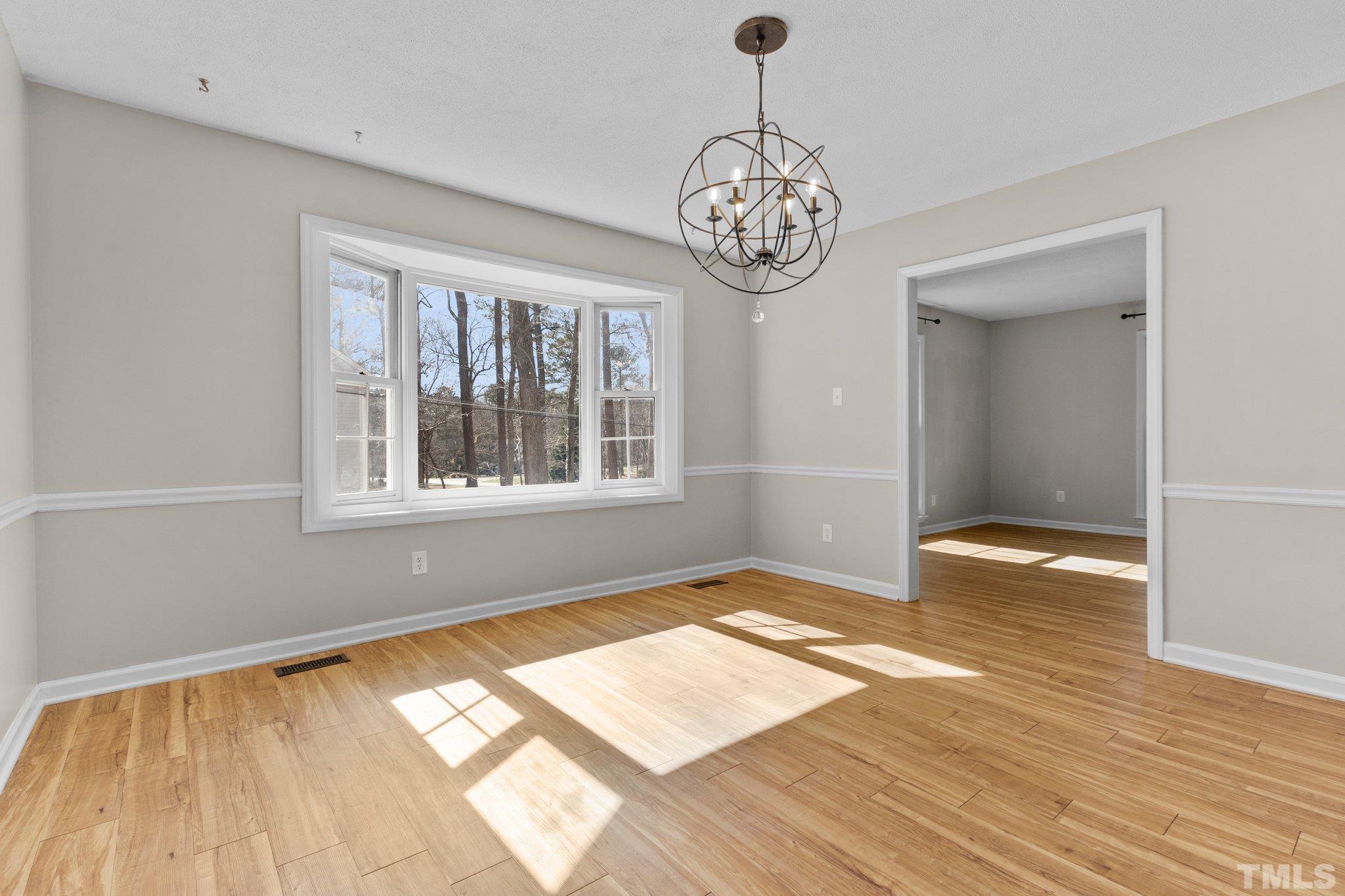 5216 Hallmark Road Durham, NC 27712 - Photo 5 of 24 a view of an empty room with wooden floor and a window