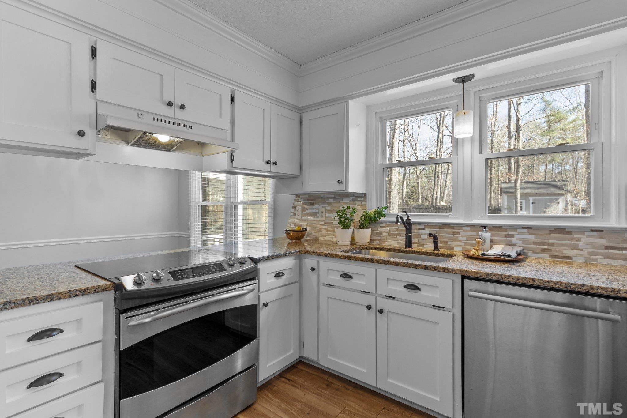 5216 Hallmark Road Durham, NC 27712 - Photo 7 of 24 a kitchen with granite countertop white cabinets and white appliances