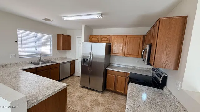 a kitchen with stainless steel appliances granite countertop a refrigerator a stove a sink and a refrigerator