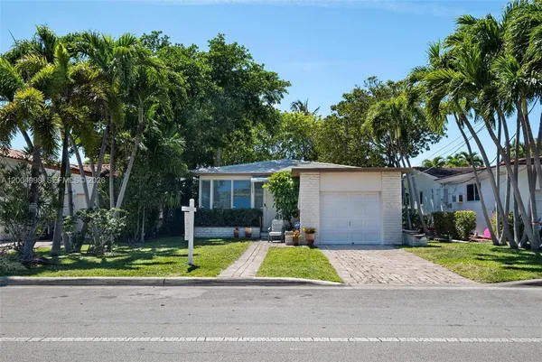 a view of a house with a yard and large trees