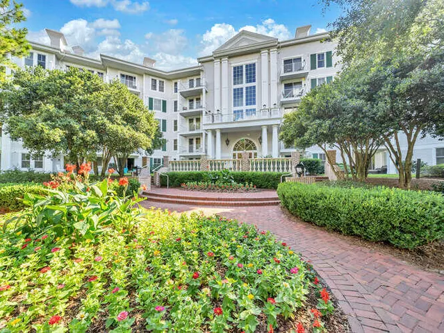 a front view of a house with a yard and fountain in middle of the house