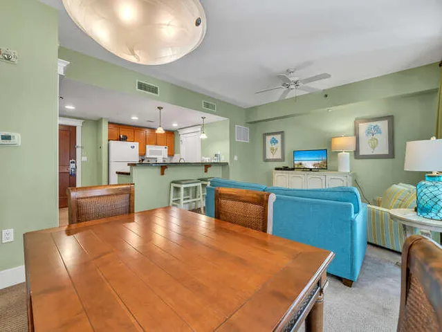 a kitchen with stainless steel appliances kitchen island granite countertop a table chairs and a refrigerator