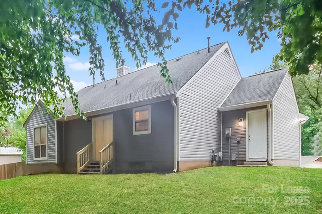 a view of a house with a yard and a tree