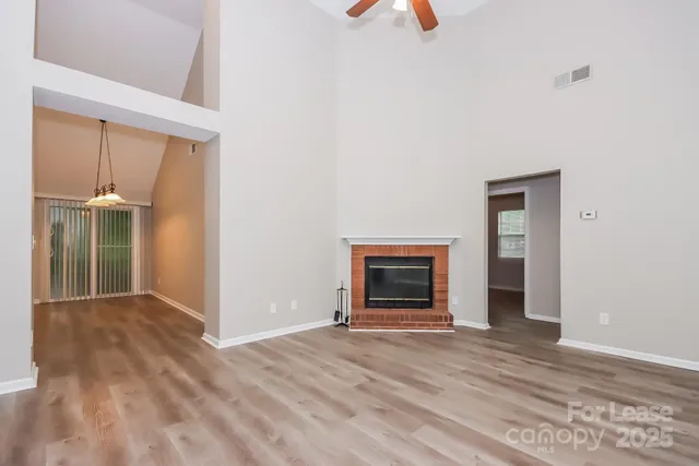 a view of empty room with wooden floor and fireplace