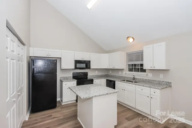 a kitchen with a sink a refrigerator and cabinets