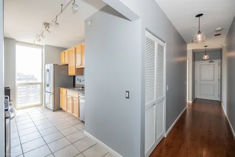 a view of hallway with wooden floor and chandelier