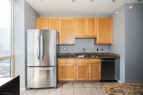 a kitchen with a refrigerator a stove a sink and a window