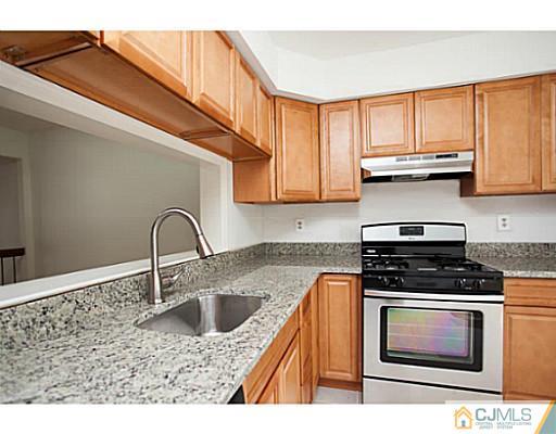 302 Timber Oaks Road Edison, NJ 08820 - Photo 4 of 16 a kitchen with stainless steel appliances granite countertop a sink stove and cabinets