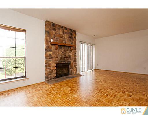 302 Timber Oaks Road Edison, NJ 08820 - Photo 5 of 16 a view of an empty room with wooden floor and a fireplace