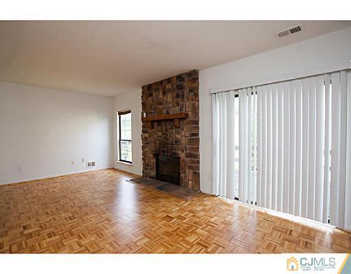 302 Timber Oaks Road Edison, NJ 08820 - Photo 6 of 16 a view of an empty room with a fireplace and a window