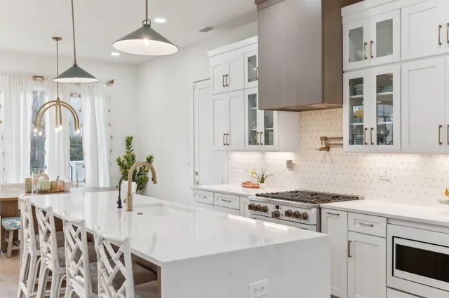 a large kitchen with kitchen island a sink a center island a stove and a cabinets