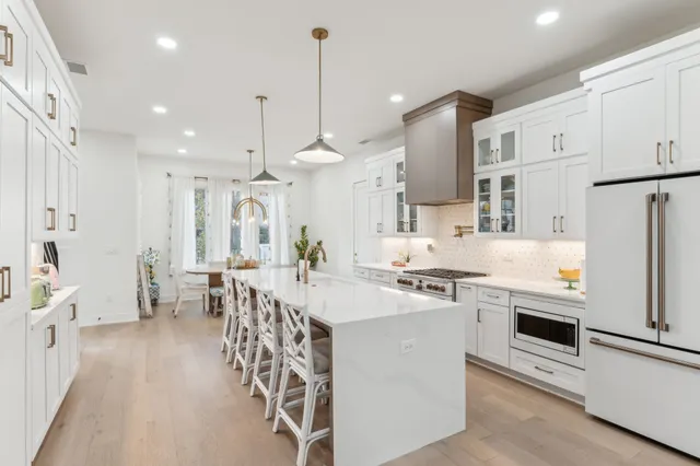 a large kitchen with kitchen island a sink a center island a stove and a cabinets