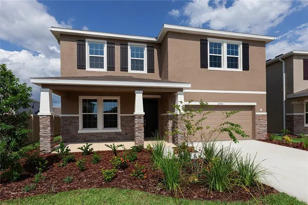 a front view of a house with a yard and potted plants