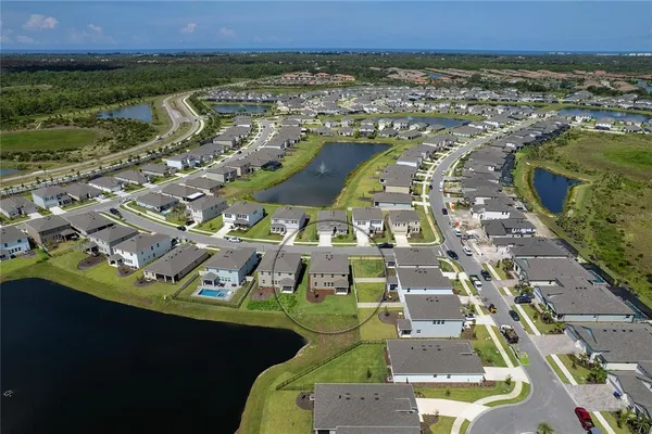 an aerial view of a house with a yard and lake view