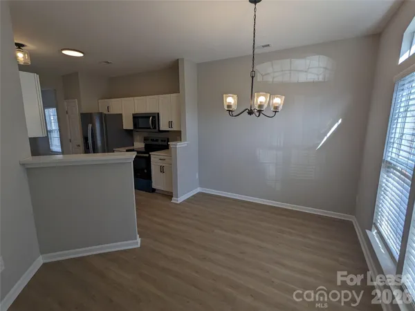 a view of a kitchen with a sink wooden floor and a window