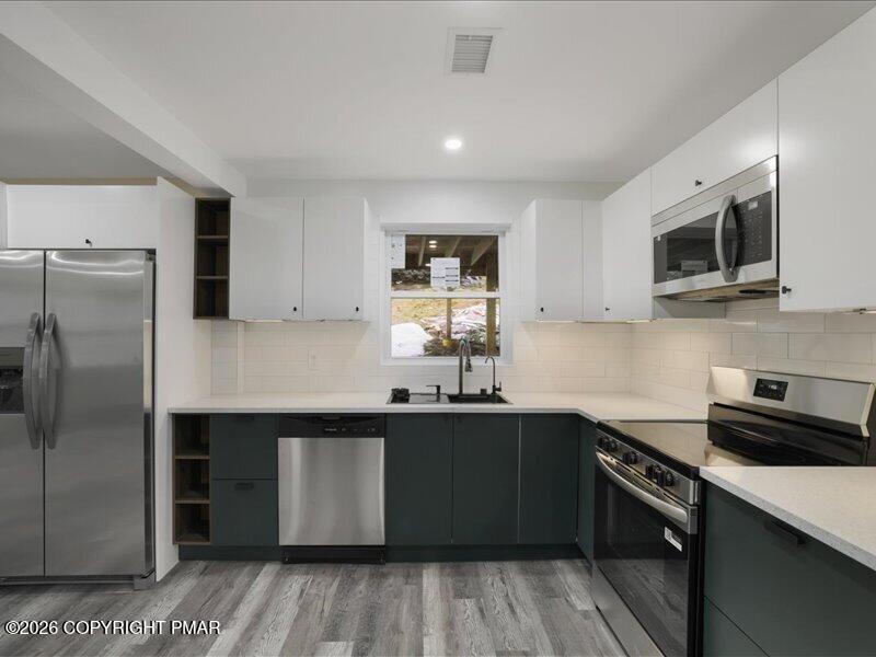 689 Main Road Hunlock Creek, PA 18621 - Photo 34 of 38 a kitchen with stainless steel appliances granite countertop a sink stove and refrigerator