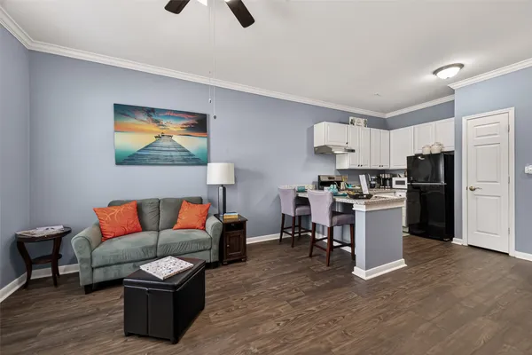 a living room with furniture kitchen view and a refrigerator