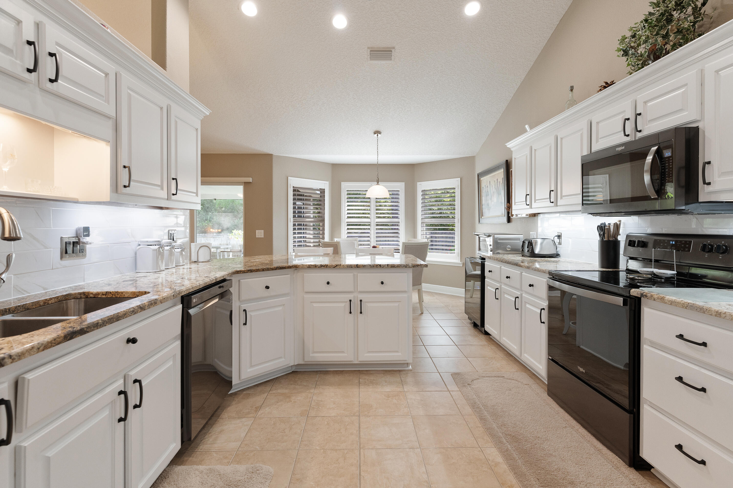 2300 Valley Place Navarre, FL 32566 - Photo 18 of 81 a kitchen with stainless steel appliances granite countertop a sink and dishwasher a stove top oven with white cabinets