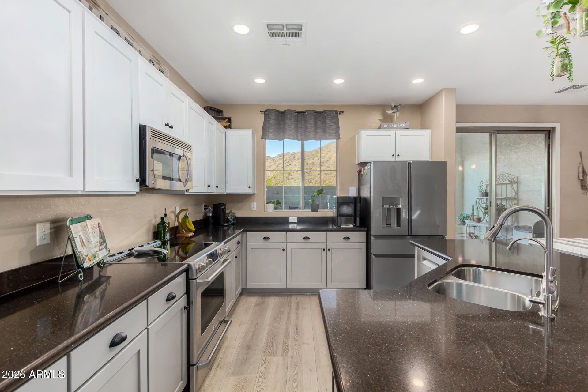 7316 West Montgomery Road Peoria, AZ 85383 - Photo 12 of 49 a kitchen with a sink a refrigerator and cabinets