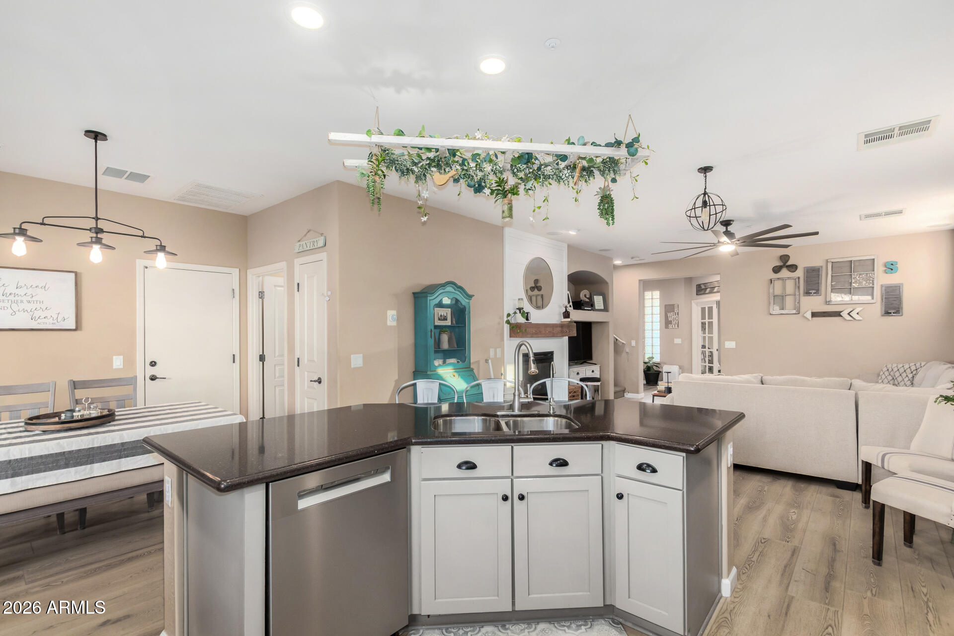 7316 West Montgomery Road Peoria, AZ 85383 - Photo 13 of 49 a kitchen with kitchen island granite countertop a sink cabinets and wooden floor